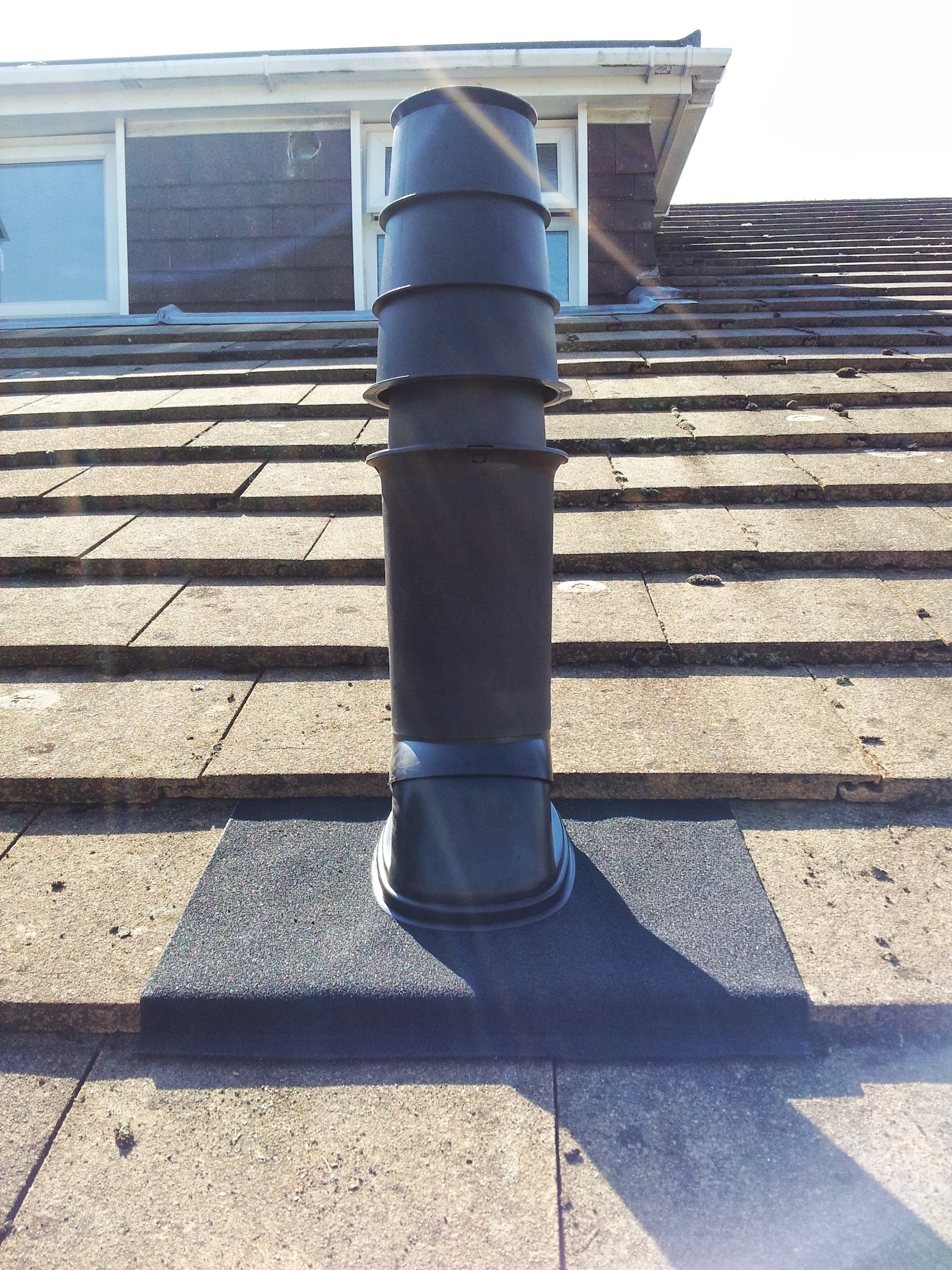 A capped and cowled flue on the roofline — safe termination is as much a part of the job as the boiler itself.