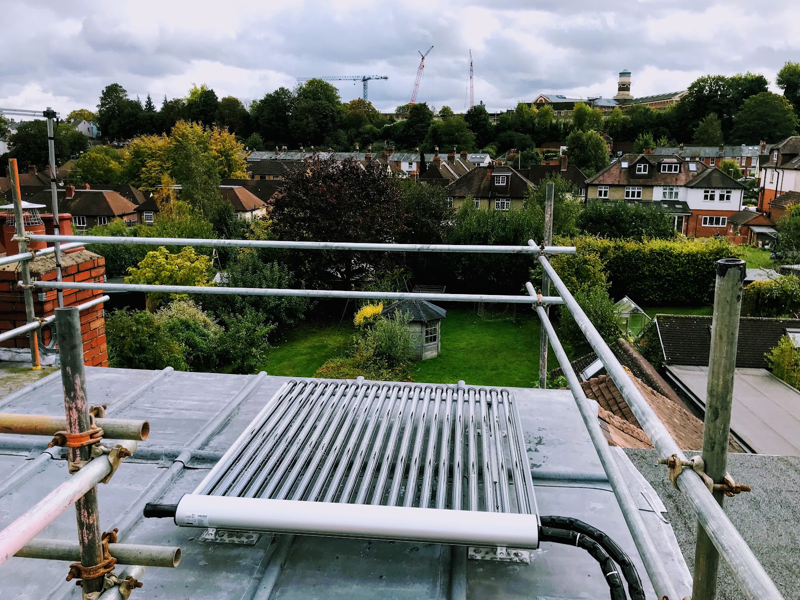 Evacuated-tube solar thermal collectors on a roof overlooking Winchester — we repair and maintain all types, including orphaned systems.